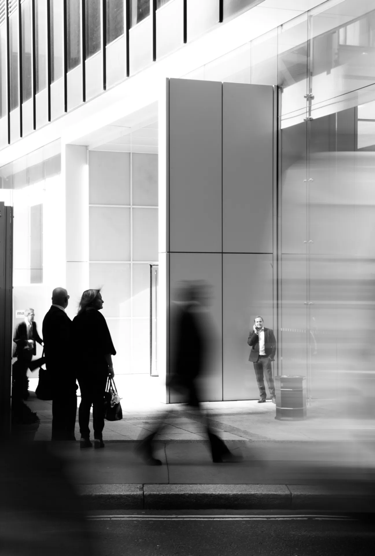 Passants dans le hall vitré d'un immeuble de bureaux