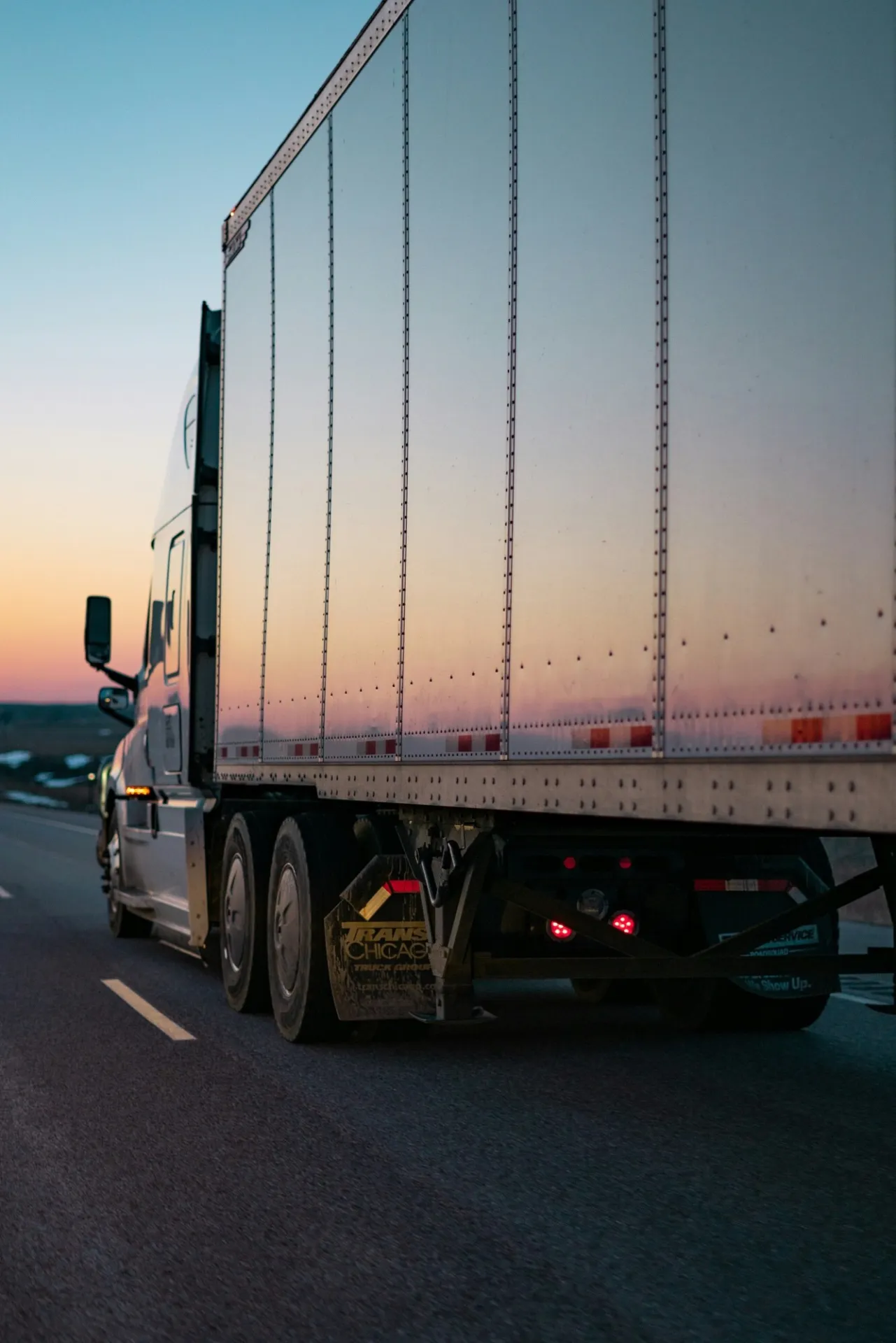 Semi-trailer truck on the road at dusk