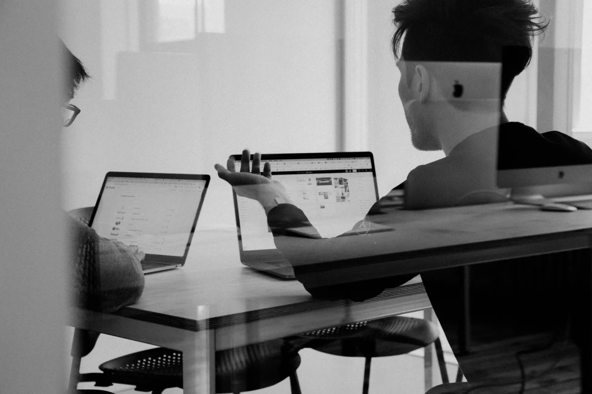 Deux personnes qui travaillent face à face avec leurs portables